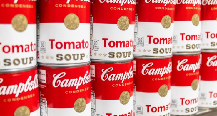 A closeup photo two rows of Campbell's tomato soup cans.