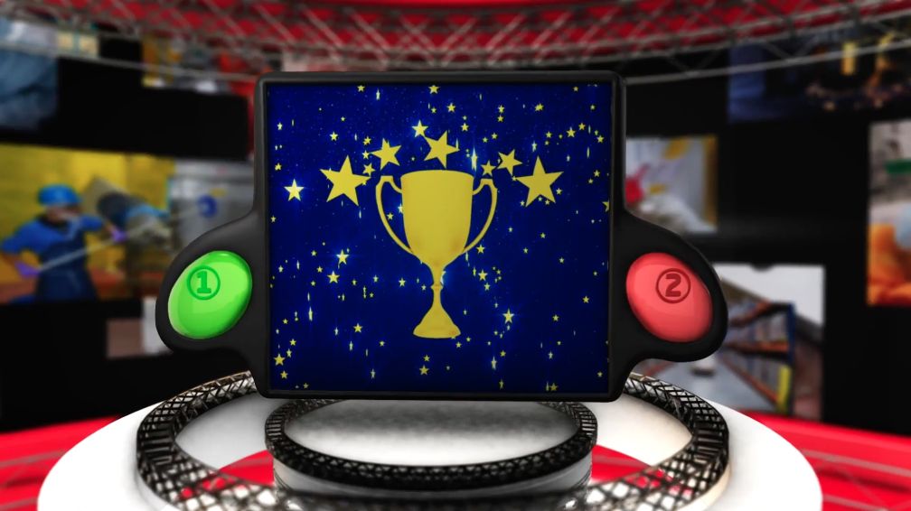 Screen shot of the Game Show in Alchemy Creator showing a game screen with a trophy on a blue field of golden stars. Player choice buttons labeled 1 (green)  and 2 (red) are on either side of the game screen.